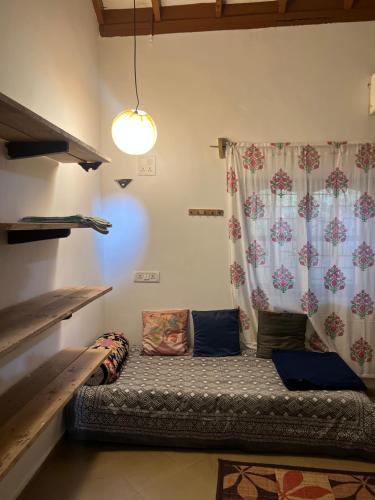 a couch sitting in a room with a curtain at The Sunset Chalet in Anjuna
