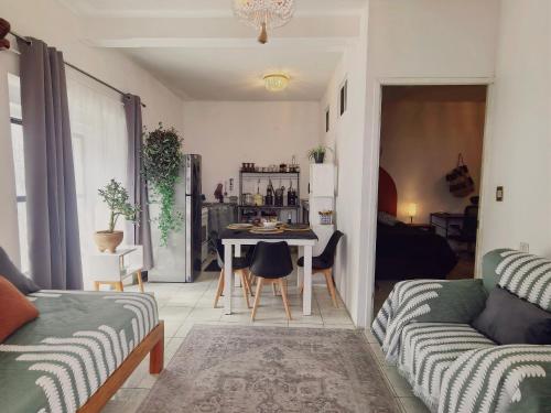 a living room with a table and a couch at Casa completa en Jalatlaco con cocina equipada y parking hasta 7 huéspedes in Oaxaca City