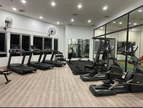 a gym with several treadmills and elliptical machines at Taragon Puteri Bintang KLCC View Studio Apartment in Kuala Lumpur