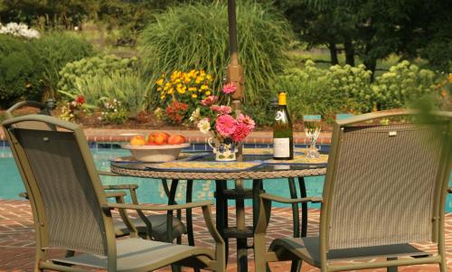 a table with two chairs and a bottle of wine at L'Auberge Provencale Inn & Restaurant in Boyce