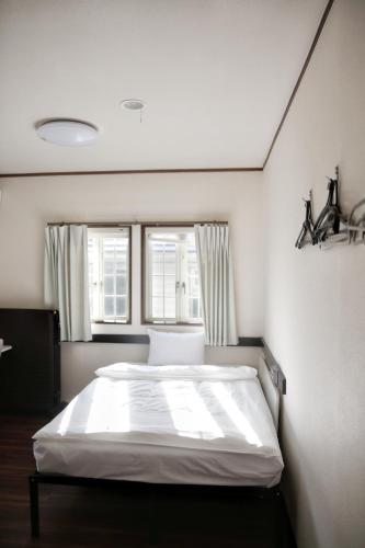 a bedroom with a large white bed in front of a window at WinVilla-Mt Fuji富士山 in Yamanakako