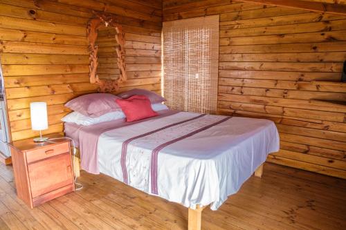 sypialnia z łóżkiem w drewnianym domku w obiekcie Cabañas Matavai w mieście Hanga Roa