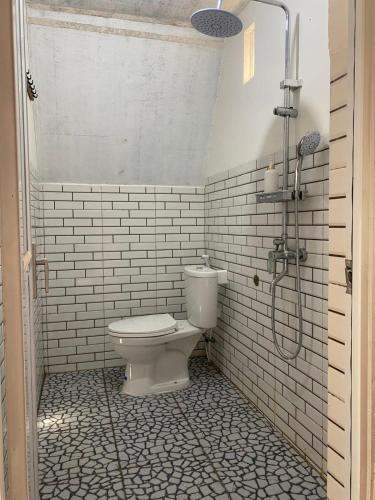 a bathroom with a toilet and a shower at Roman Villa Syariah in Sembalun Lawang