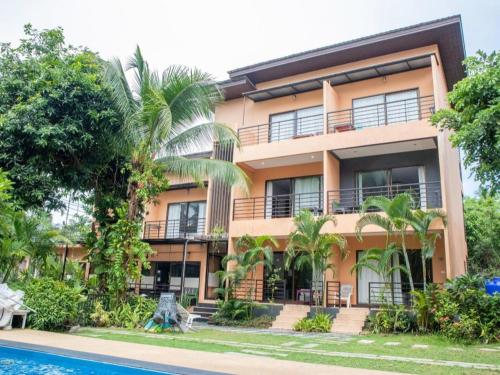 an exterior view of a building with a swimming pool at OYO 567 U Residence in Ban Lamai