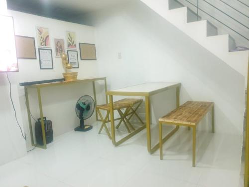 een kamer met twee tafels, een bank en een trap bij Fernica Boarding House in Carmona