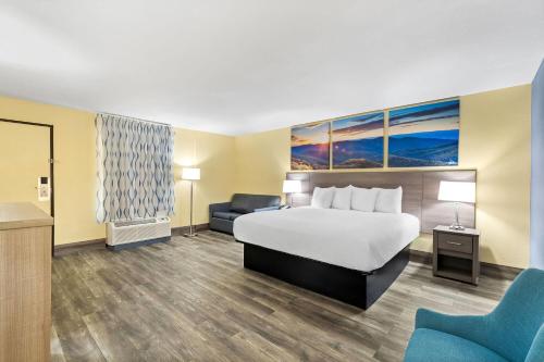 a hotel room with a bed and a chair at Days Inn by Wyndham Cleveland TN in Cleveland