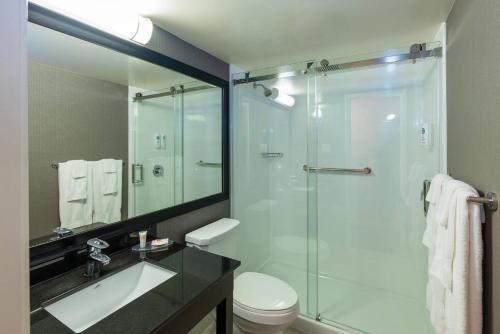 a bathroom with a glass shower with a toilet and a sink at Comfort Inn in Yarmouth