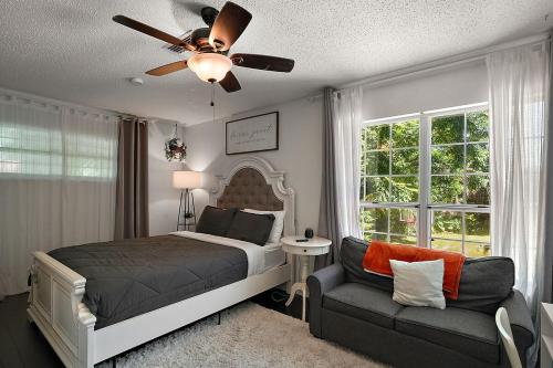 ein Schlafzimmer mit einem Bett, einem Sofa und einem Deckenventilator in der Unterkunft The Perfect Family Vacation Home in Mount Dora