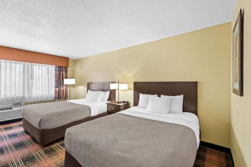 a hotel room with two beds and a window at Quality Inn & Suites Des Moines Airport in Des Moines
