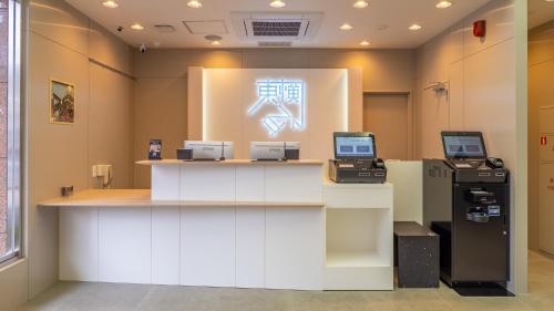 an office with a cash counter with two computers on it at Toyoko Inn Tokyo Minowa-eki in Tokyo