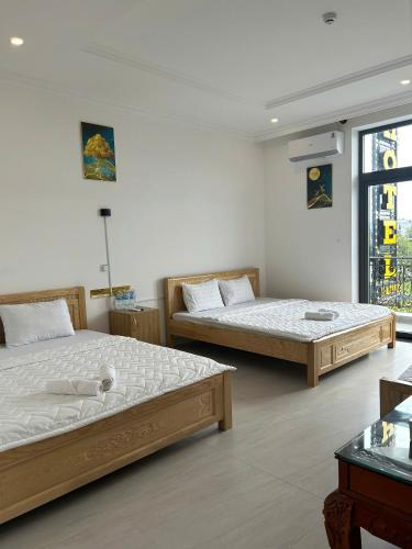 a bedroom with two beds and a window at Khách sạn Phúc Đạt - Rạch Giá Phúc Đạt Hotel in Ấp Rạch Mẹo