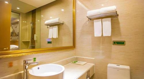 a bathroom with a sink and a mirror and a toilet at Vienna Hotel Shenzhen Bao'an Airport Taoyuanju Pingluanshan Metro Station in Xin'an