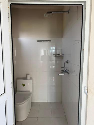 River Tiger Safari & Homestay في Meghauli: حمام ابيض مع مرحاض ودش