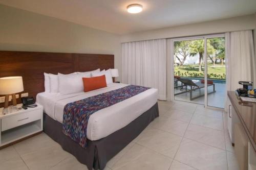 Celuisma Playa Dorada All Inclusive في Cantabria: غرفة نوم مع سرير كبير وشرفة