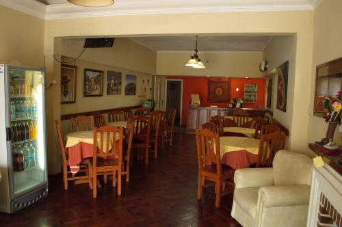 a restaurant with tables and chairs and a refrigerator at Rutas Hotel in Salta