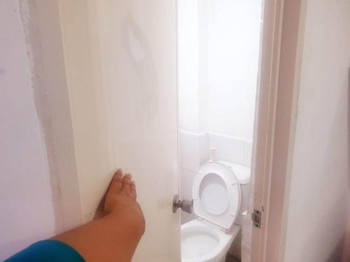een persoon in een badkamer met toilet bij Fernica Boarding House in Carmona