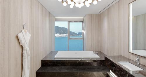 a bathroom with a tub and a large window at Wyndham Grand Busan in Busan