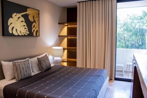 a bedroom with a bed and a large window at Peregrina Tulum 202C 1 Bedroom Condo in Tulum