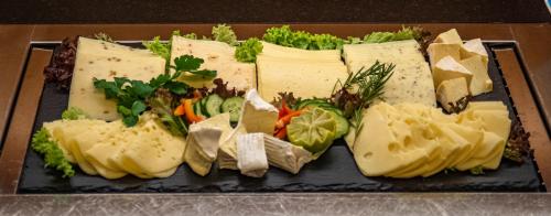 a plate of different types of cheese and vegetables at Hotel-Restaurant Gasthaus Bonimeier in Niedergottsau