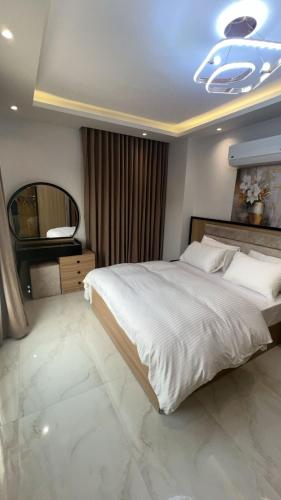 a bedroom with a large bed and a mirror at Doki sky suite in Cairo