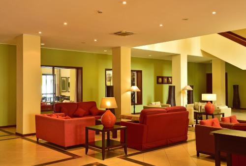 a living room with red furniture and green walls at Pestana Sao Tome in São Tomé