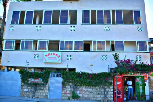 ein weißes Gebäude mit einer Soda-Maschine davor in der Unterkunft Ariosa Apartments in Mtwapa