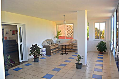 a living room with potted plants on a tile floor at Ariosa Apartments in Mtwapa