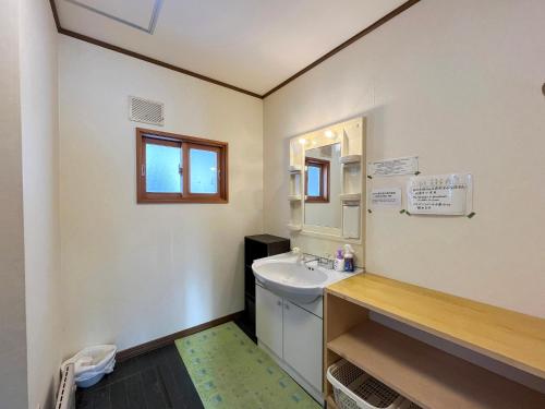 een badkamer met een wastafel en een spiegel bij Natsumi no Sato in Biei