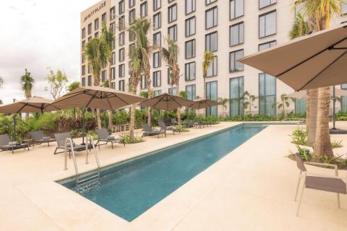 an image of a hotel pool with umbrellas at Hyatt Place Cancun Airport in Cancún