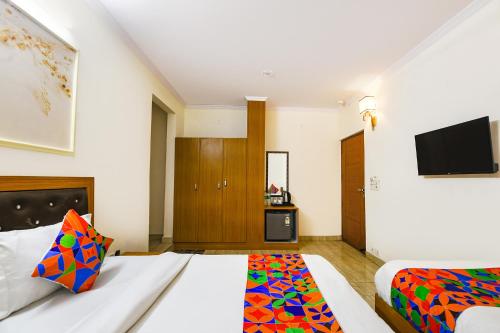 Una habitación de hotel con una cama y un televisor. en FabHotel The Rivlet Centre, en Nueva Delhi