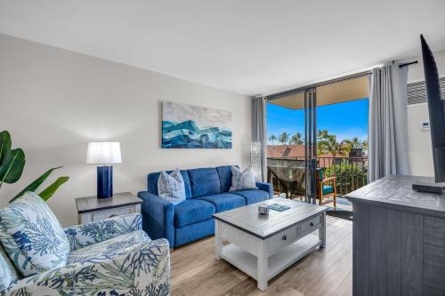 a living room with a blue couch and a table at Hip Oceanfront Resort Vistas in Kihei