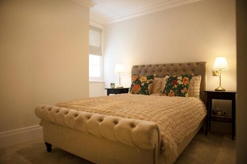 a bedroom with a large bed with two lamps at Grade II listed 3 bed townhouse in Exeter, Devon in Exeter