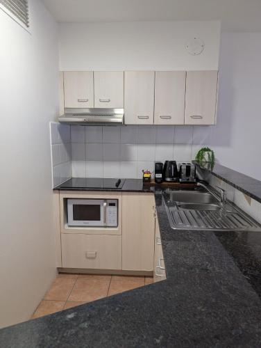 a kitchen with a sink and a microwave at Inn Cairns in Cairns