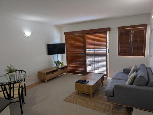 a living room with a couch and a table at Inn Cairns in Cairns