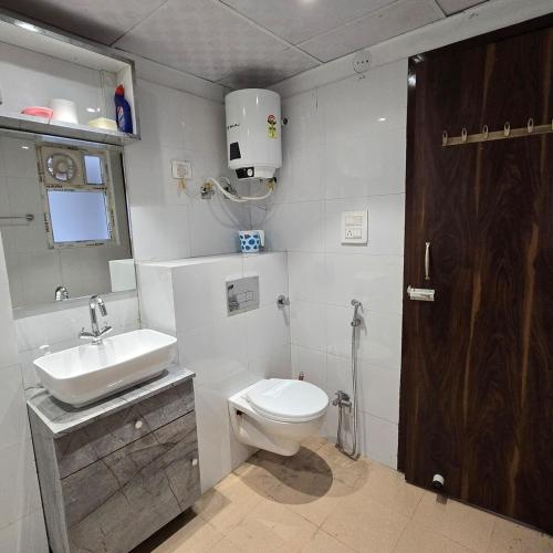 a bathroom with a toilet and a sink at Luxury Studio Apartment in Bareilly in Bareilly