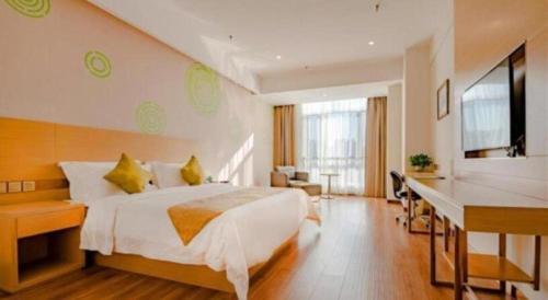 a hotel room with a large bed and a desk at GreenTree Inn Qufu High Speed Railway Station in Qufu