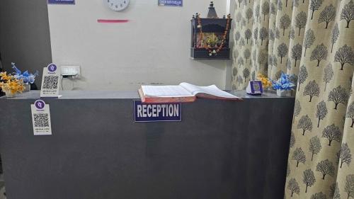 un mostrador de recepción con un cartel de registro. en Hotel O golden blue, en Noida