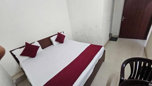 Un dormitorio con una cama con almohadas rojas y blancas. en Hotel O golden blue, en Noida