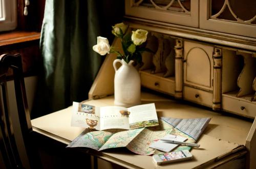 a table with a vase of flowers and a map at American Guest House, a Washington DC Bed and Breakfast in Washington