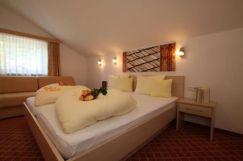 a bedroom with a large bed with white sheets at Karlspitze -Natur Pur Appartementhaus in Kaunertal
