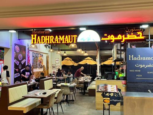 um restaurante com mesas e cadeiras e uma placa em Cameron Highlands homestay em Brinchang