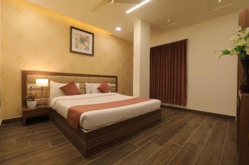 una camera da letto con un letto grande in una stanza di Hotel Shiv Shakti a Rajkot