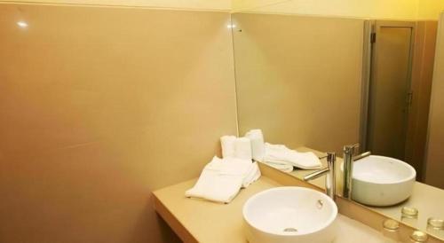 un baño con lavabo y espejo en Griya Sintesa, en Manado