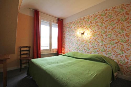 a bedroom with a green bed and a window at Gite Le Relais Saint Michel in Domfront