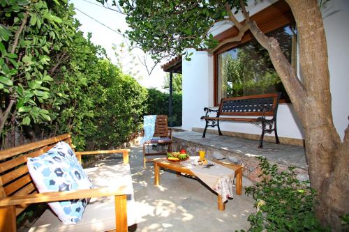 a patio with a bench and a table at Yianna Sunny Studios in Skopelos Town