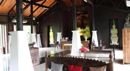 a living room with a couch and a table and chairs at Chivaree Hotel and Resort in Ban Mu Dut