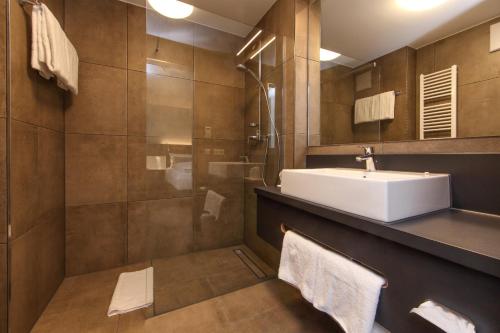 a bathroom with a sink and a shower at Design & Lifestyle Hotel Estilo in Aalen