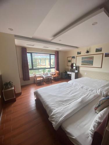 a bedroom with a large bed and a large window at SaPa Global Hotel in Sapa