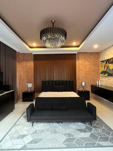 a bedroom with a bed and a chandelier at Highland Villas Royale Corp in Alfonso