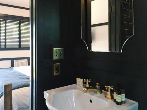 a bathroom with a sink and a mirror and a bed at Brentwood Hotel in Saratoga Springs